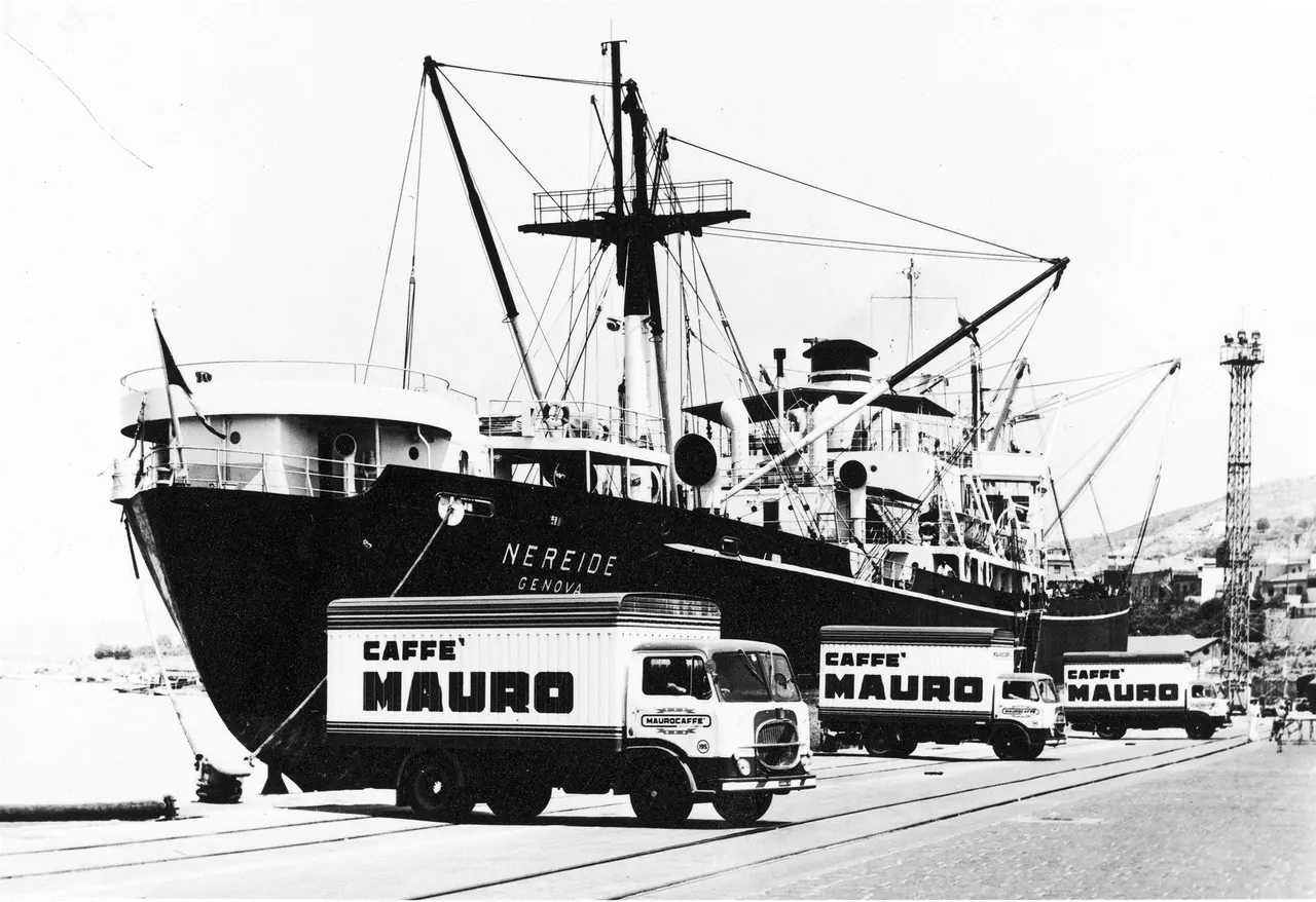 Historic photo of Caffè Mauro trucks on the quay beside a cargo ship